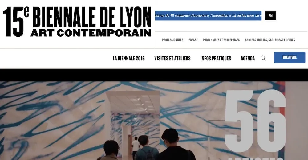 Page d'accueil du site de la 15e Biennale de Lyon art contemporain : menu (La Biennale 2019, Visites et ateliers, Infos pratiques, Agenda, Billetterie) au-dessus d'une photo de visiteurs dans l'exposition